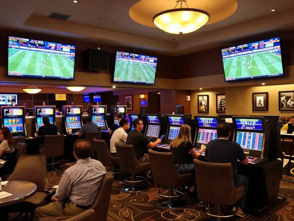 Engaging patrons analyzing tỷ lệ kèo while placing bets in an upscale sports betting lounge.